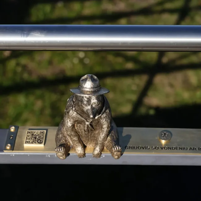 Palaptingas užrašas šalia skautiškos meškutės